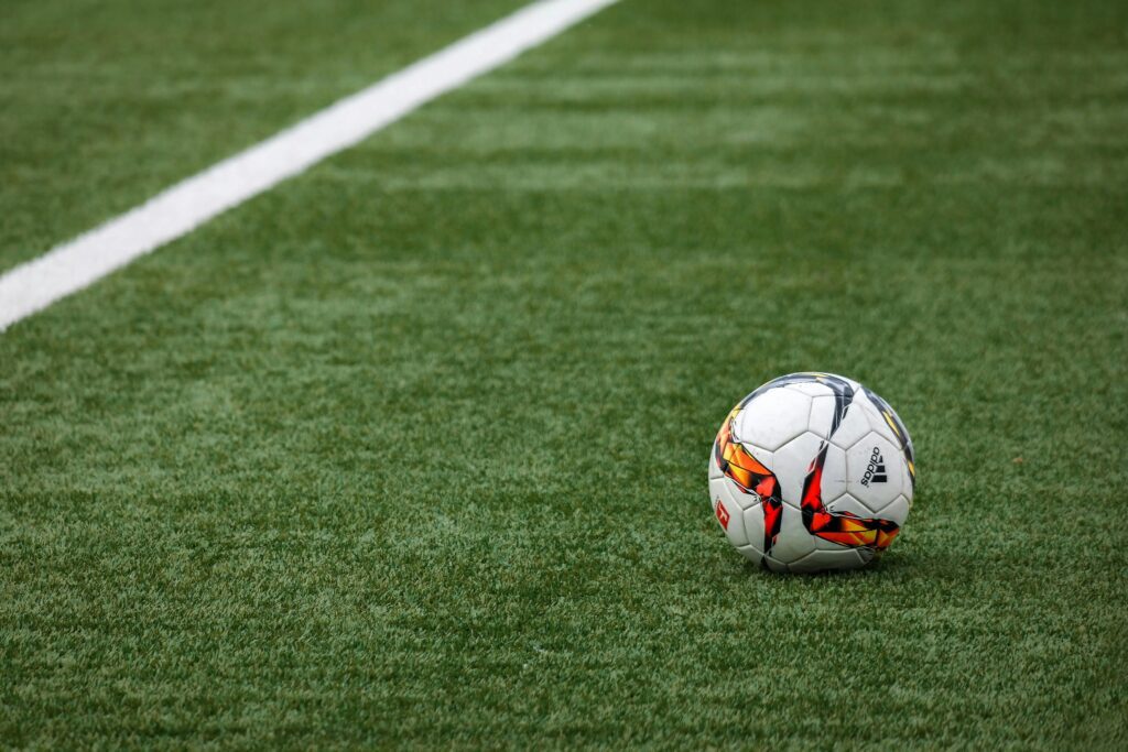 Image of a soccer ball on a soccer pitch.